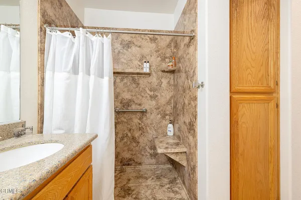 a bathroom with a granite countertop shower curtain and a sink