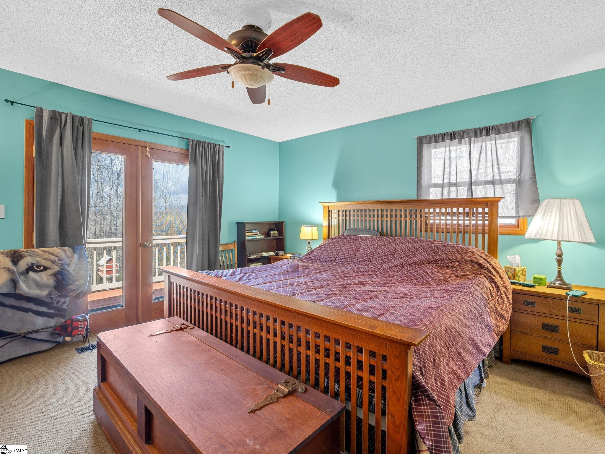 405 Loop Road Campobello, SC 29322 - Photo 11 of 49 The primary ensuite bedroom on the main level has access to the deck and a walk-in closet