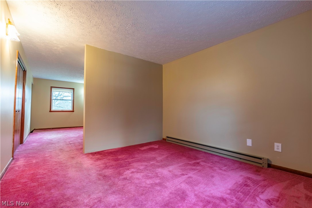 2159 Portage Line Road Mogadore, OH 44260 - Photo 32 of 35 Unfurnished room featuring a textured ceiling, light colored carpet, and baseboard heating