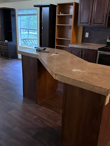 a kitchen with kitchen island a sink wooden floor and a window