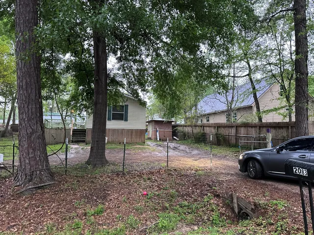 a view of a house with a backyard and a trees