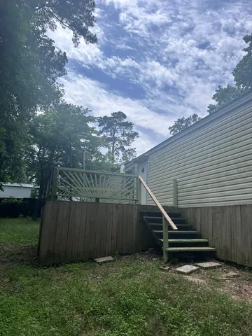 a view of a backyard with plants and wooden fence