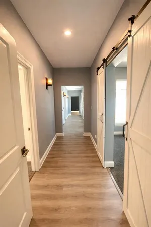 a view of a hallway with wooden floor and staircase