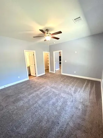 an empty room with windows and fan