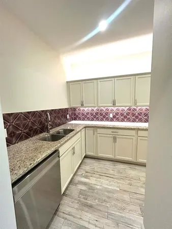 a kitchen with stainless steel appliances granite countertop a sink and cabinets