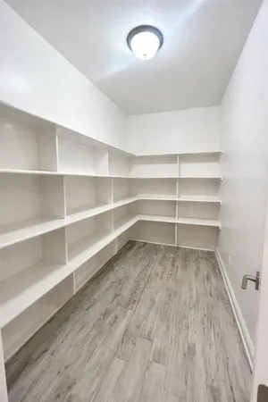 a view of walk in closet with empty racks