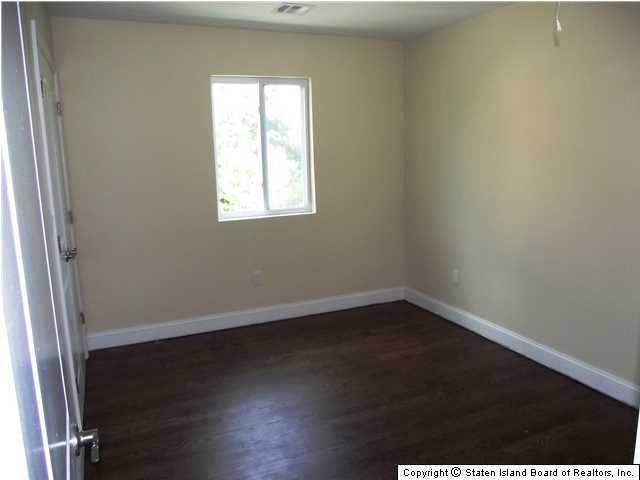29 Midland Road Staten Island, NY 10308 - Photo 11 of 20 an empty room with wooden floor and windows