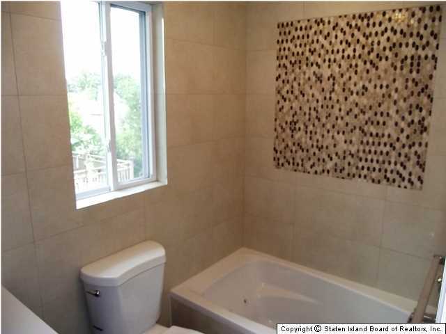 29 Midland Road Staten Island, NY 10308 - Photo 15 of 20 a bath tub sitting next to a white toilet and a shower