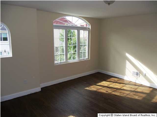 29 Midland Road Staten Island, NY 10308 - Photo 16 of 20 a view of an empty room with wooden floor and a window