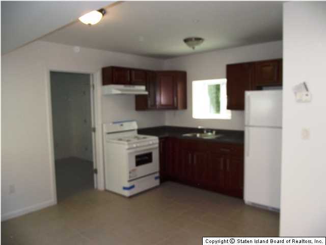 29 Midland Road Staten Island, NY 10308 - Photo 17 of 20 a kitchen with a stove and a refrigerator