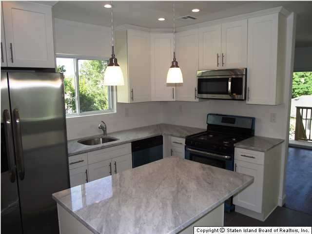 29 Midland Road Staten Island, NY 10308 - Photo 6 of 20 a kitchen with stainless steel appliances granite countertop a stove a sink a microwave a refrigerator and white cabinets