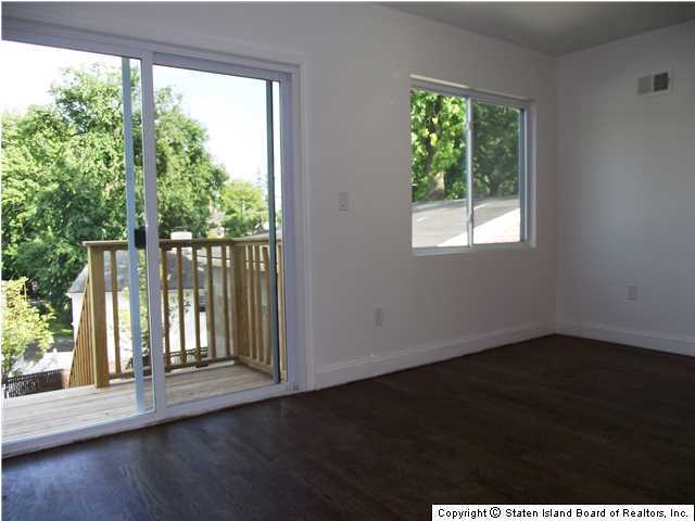 29 Midland Road Staten Island, NY 10308 - Photo 8 of 20 an empty room with wooden floor and windows