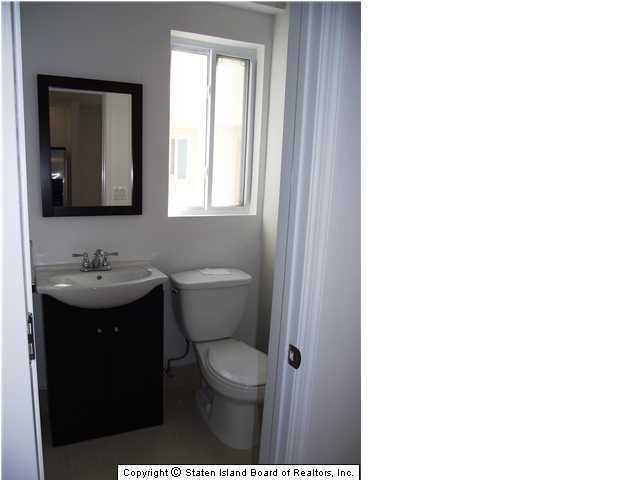 29 Midland Road Staten Island, NY 10308 - Photo 9 of 20 a bathroom with a granite countertop toilet a sink and a mirror