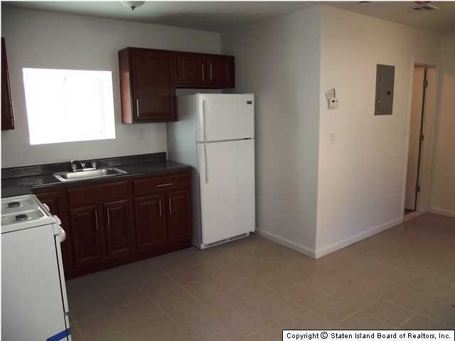 29 Midland Road Staten Island, NY 10308 - Photo 10 of 20 a room with a refrigerator and a stove