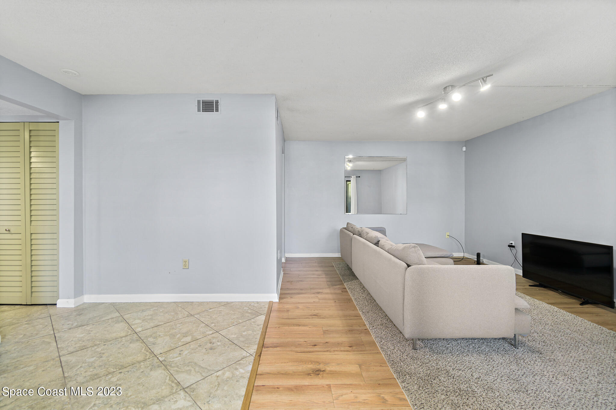 500 Catalina Road, Unit 103 Cocoa Beach, FL 32931 - Photo 11 of 28 a living room with furniture and a flat screen tv