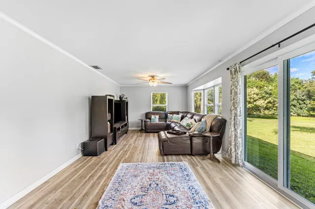 a living room with furniture wooden floor and a large window
