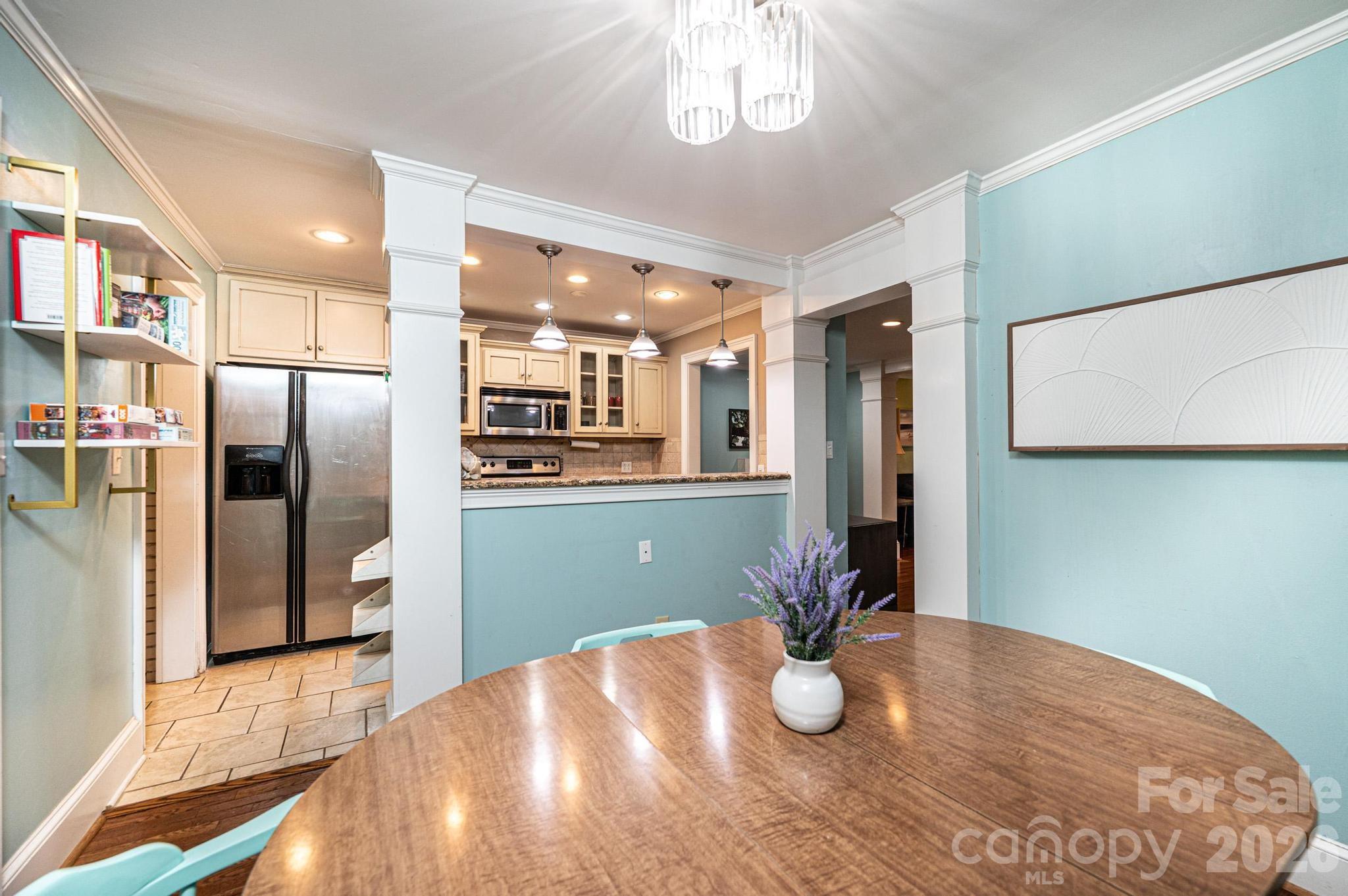 826 6th Street Northwest, Unit 4 Hickory, NC 28601 - Photo 8 of 25 a kitchen with stainless steel appliances wooden floor dining table and chairs