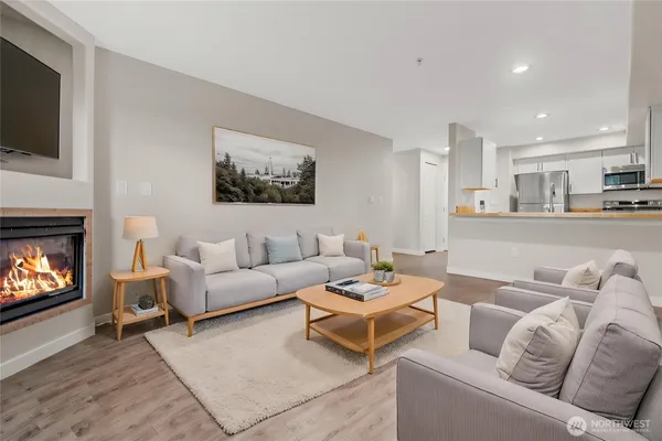 a living room with furniture a flat screen tv and a fireplace