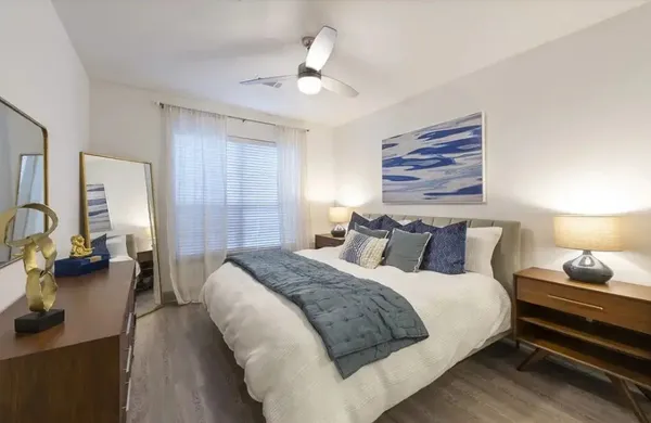 a bedroom with a bed and wooden floor