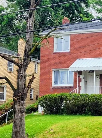 a front view of a house with a yard and potted plants