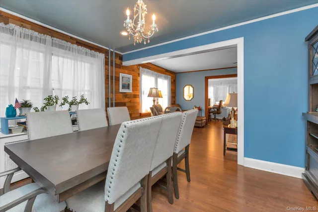 a dining room with furniture a chandelier and wooden floor