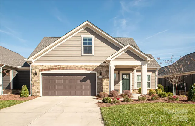 a front view of a house with a yard outdoor seating and garage