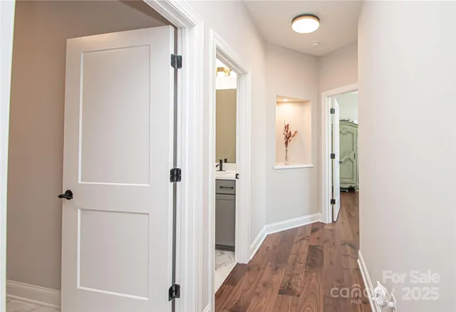a view of a hallway with wooden floor and closet