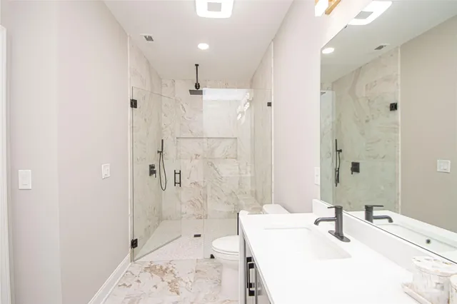 a bathroom with a sink a toilet and shower