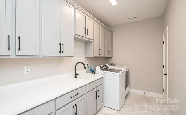a kitchen with white cabinets and sink