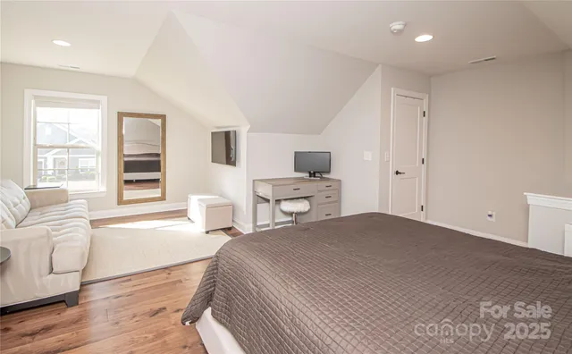 a bedroom with a bed and a couch with window