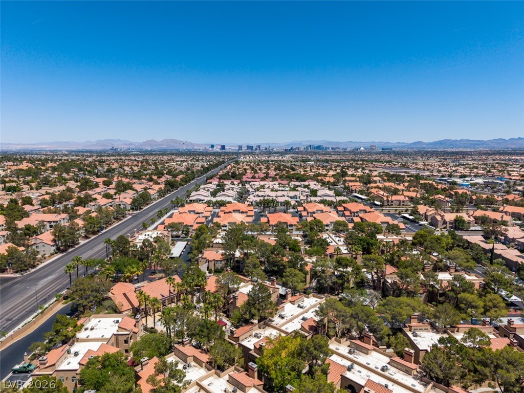9325 West Desert Inn Road, Unit 244 Las Vegas, NV 89117 - Photo 52 of 55 An aerial perspective reveals a vast community under a clear sky, extending towards distant cityscapes.