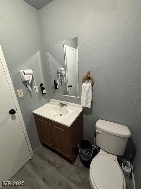 4640 Koval Lane, Unit 49A Las Vegas, NV 89109 - Photo 13 of 17 Bathroom featuring vanity, toilet, and wood finished floors