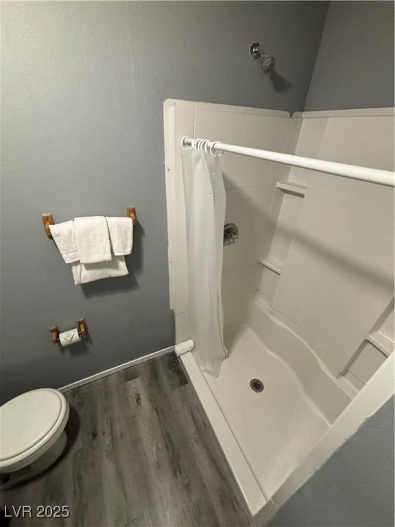4640 Koval Lane, Unit 49A Las Vegas, NV 89109 - Photo 14 of 17 Full bath featuring toilet, a stall shower, wood finished floors, and baseboards
