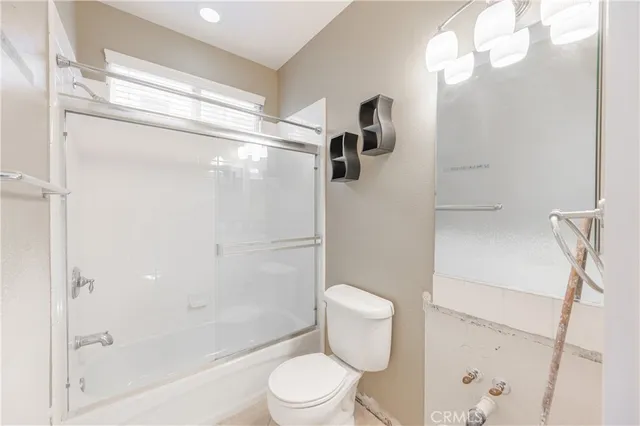 a white toilet sitting next to a bath tub shower
