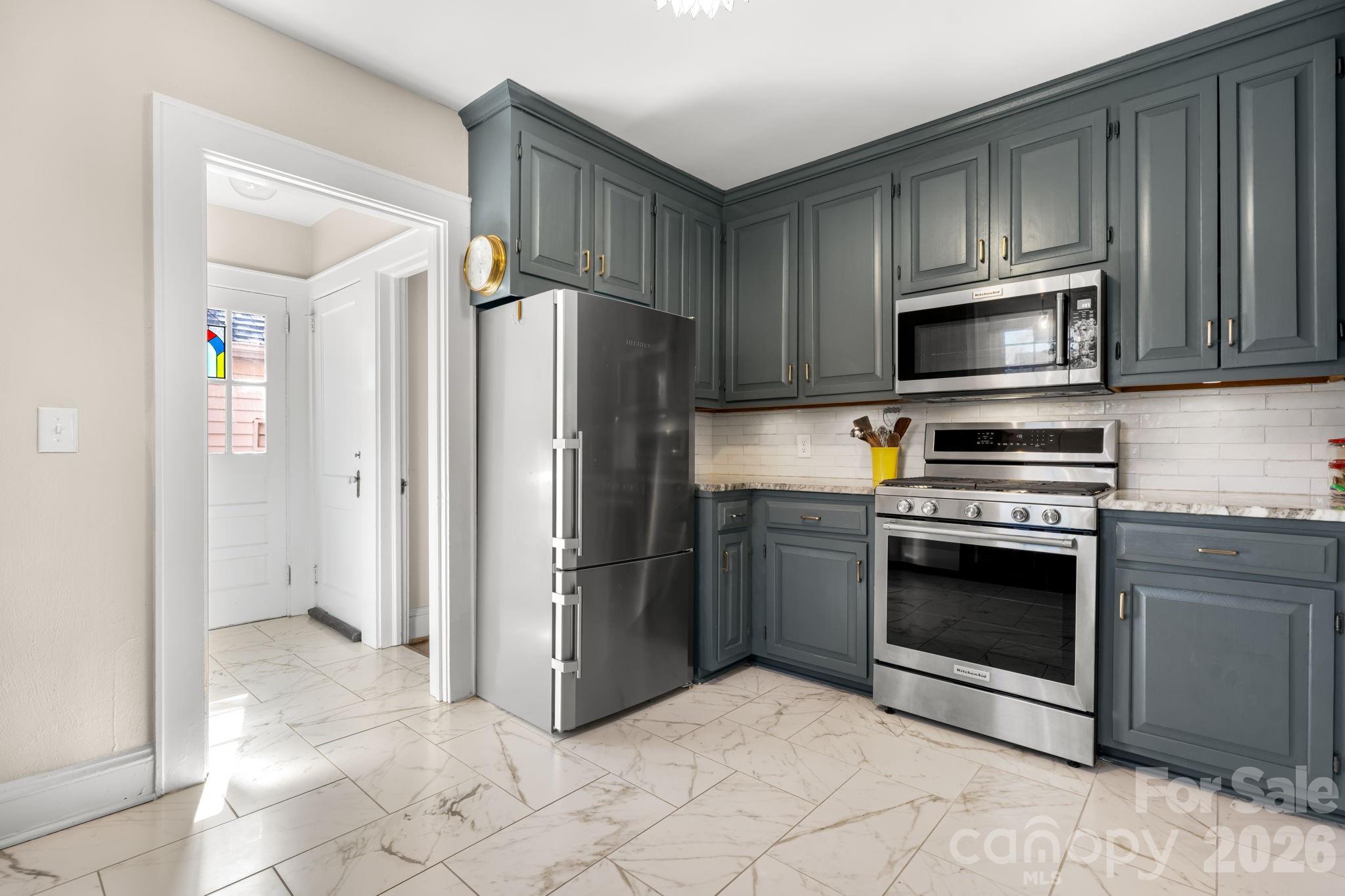 530 7th Street Northwest Hickory, NC 28601 - Photo 14 of 34 a kitchen with granite countertop a refrigerator and a stove top oven