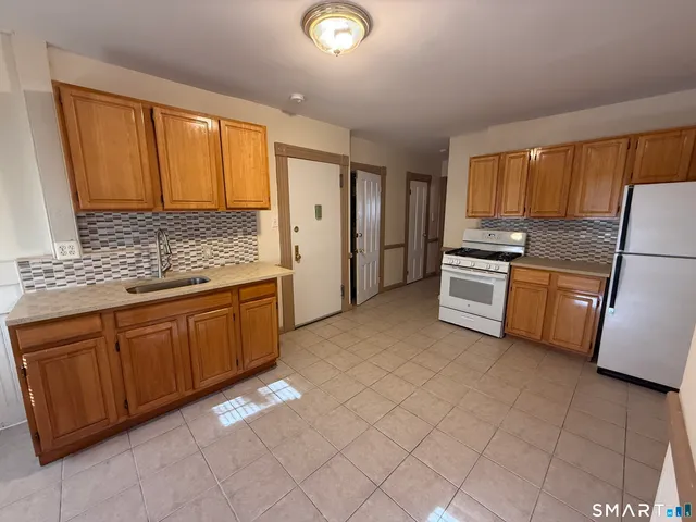 a kitchen with stainless steel appliances granite countertop a refrigerator sink and cabinets