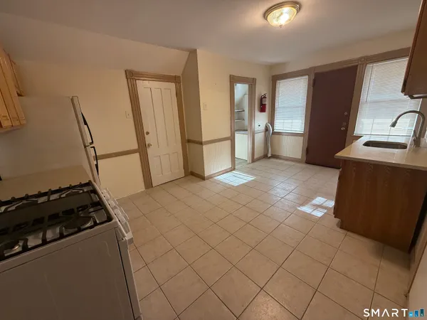 a view of a kitchen with flat screen tv and a refrigerator