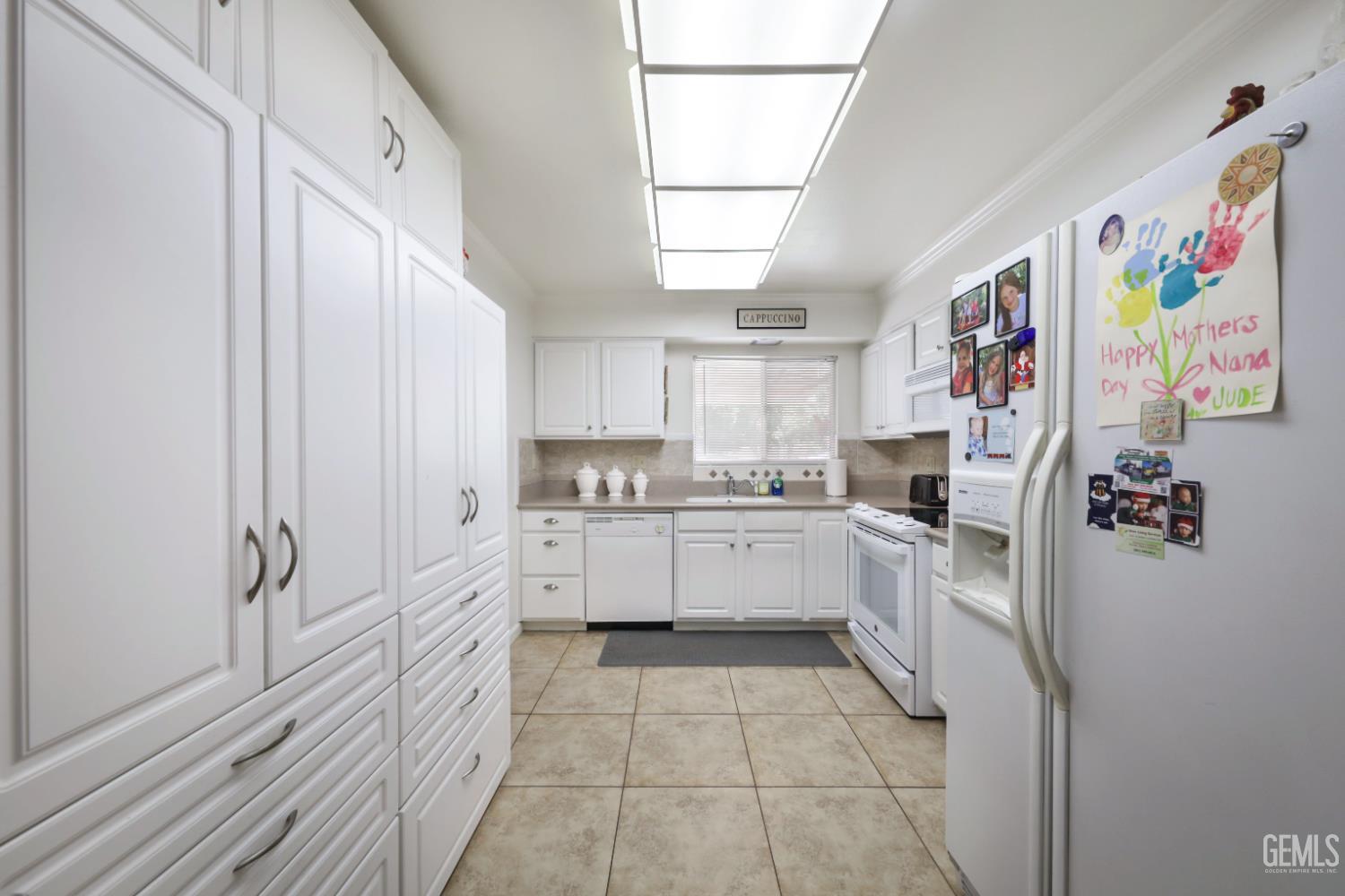 Undisclosed Address Bakersfield, CA 93309 - Photo 12 of 22 a kitchen with a refrigerator and white cabinets
