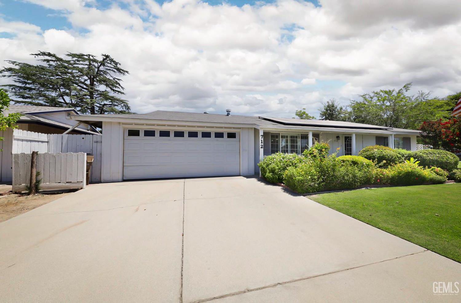 Undisclosed Address Bakersfield, CA 93309 - Photo 3 of 22 a front view of a house with a yard and garage
