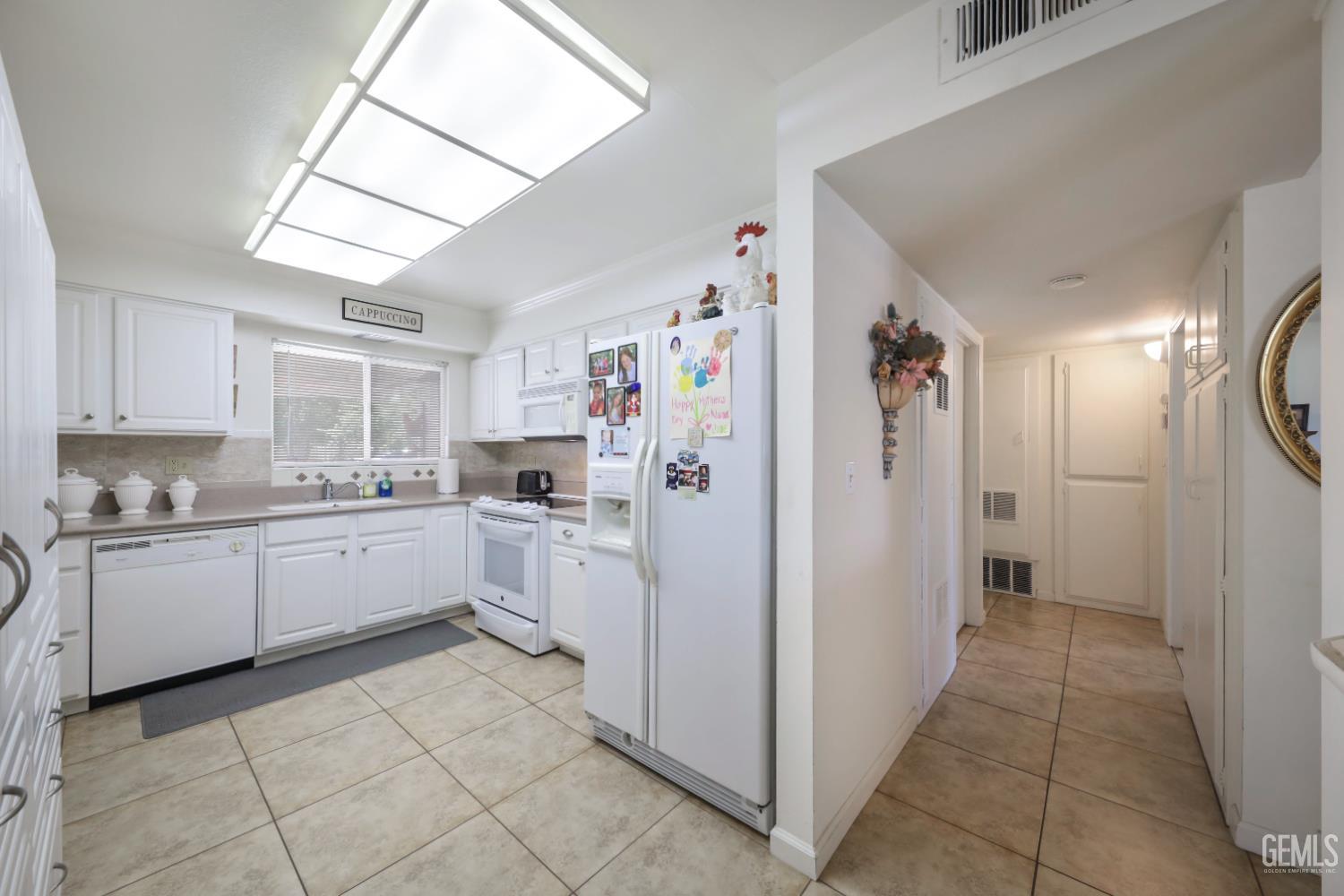 Undisclosed Address Bakersfield, CA 93309 - Photo 10 of 22 a kitchen with a refrigerator and white cabinets