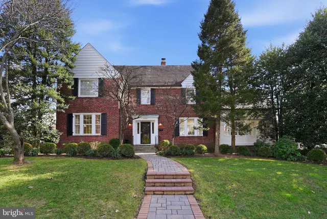a front view of a house with a yard and trees