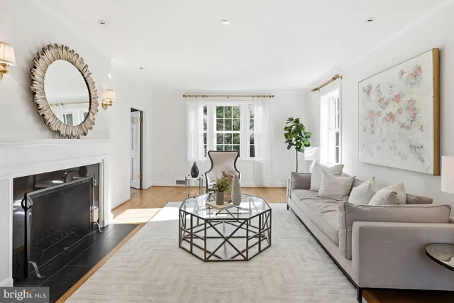 a living room with furniture a fireplace and a large window
