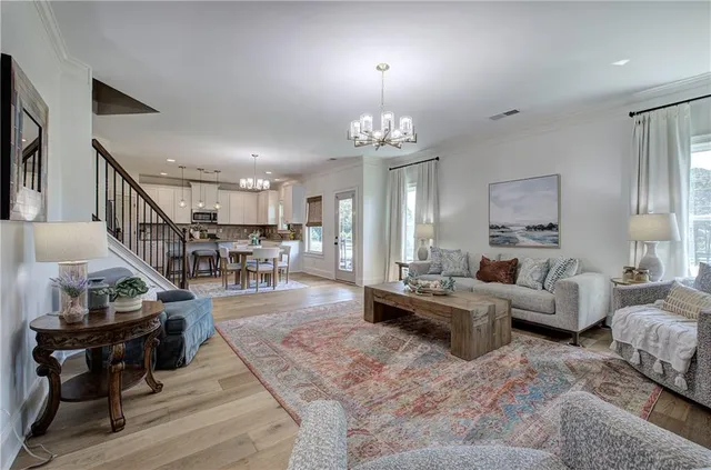 a view of a dining room with furniture a chandelier and wooden floor