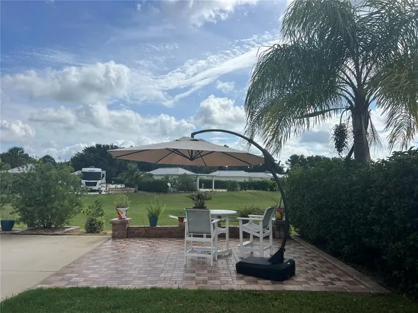 a view of a garden with a table and chairs under an umbrella