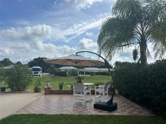 a view of a garden with a table and chairs under an umbrella