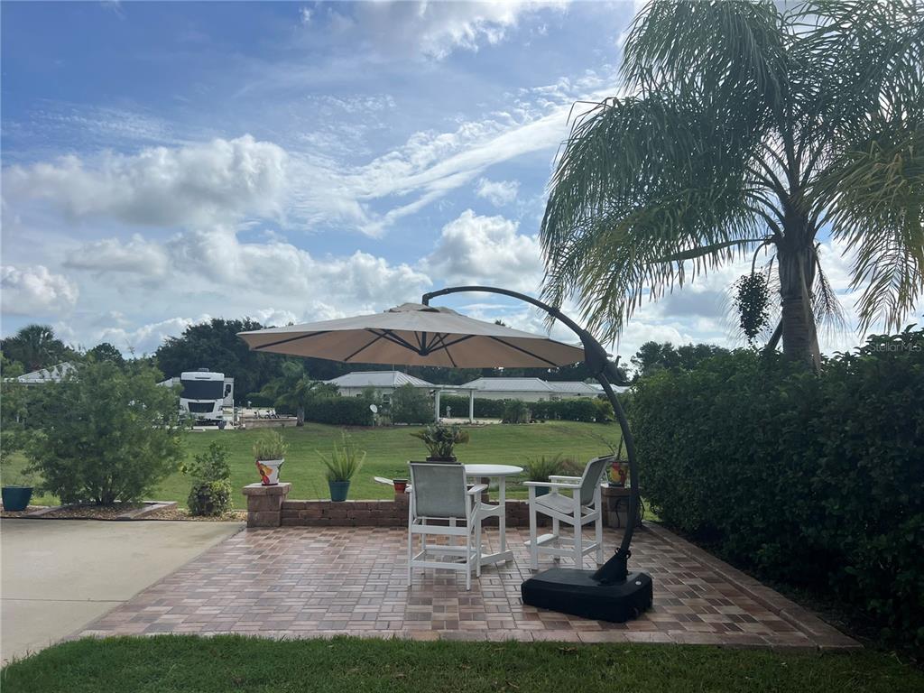 9531 Southeast 47th Way, Unit 280 Webster, FL 33597 - Photo 7 of 27 a view of a garden with a table and chairs under an umbrella