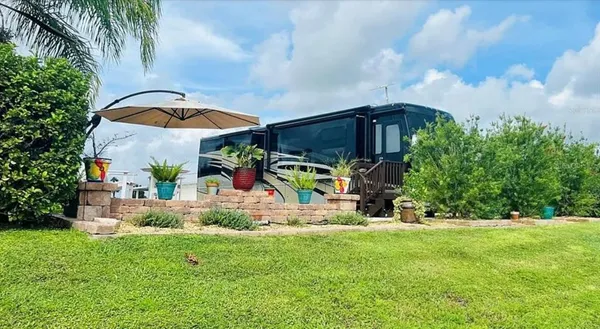 a view of a house with a yard and potted plants