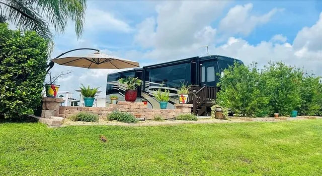 a view of a house with a yard and potted plants
