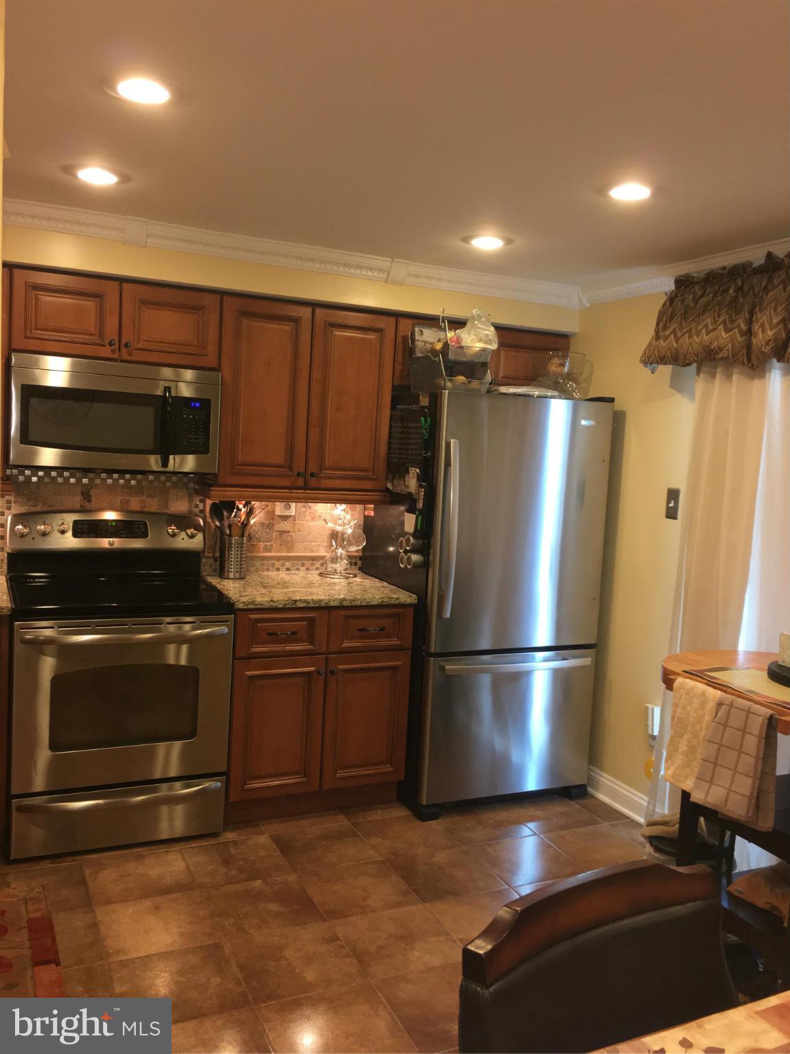 2232 Riding Crop Way Baltimore, MD 21244 - Photo 6 of 12 a kitchen with granite countertop a refrigerator stove and microwave