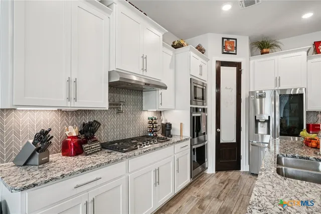 a kitchen with a stove and cabinets